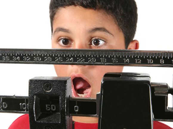 Menino se assusta com o seu próprio peso: esse excesso é fator de risco obesidade na fase adulta –Crédito: Stephen Coburn/Shutterstock